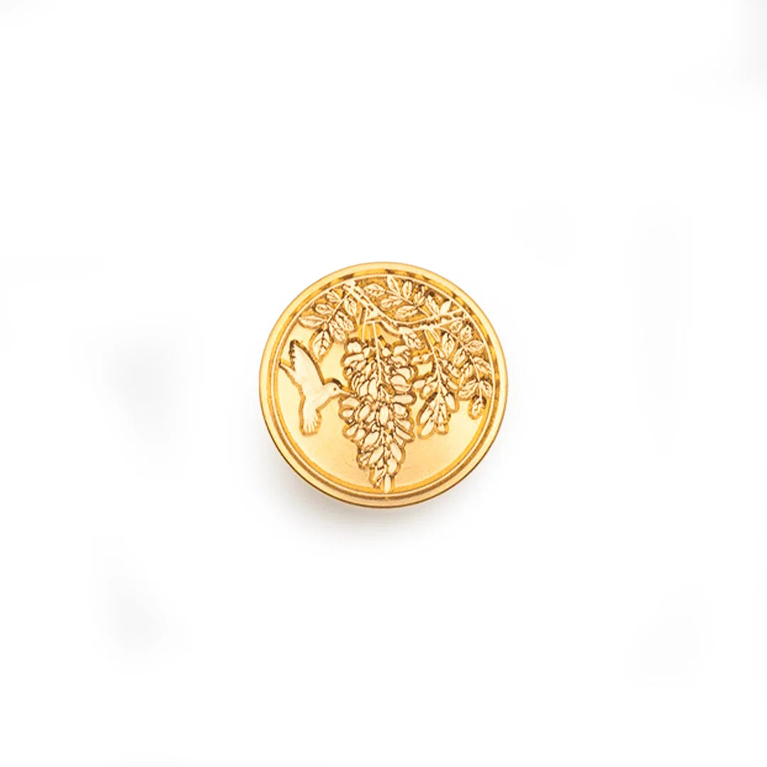 A round gold stamp-seal featuring an embossed grapevine design, shown on a plain white background.