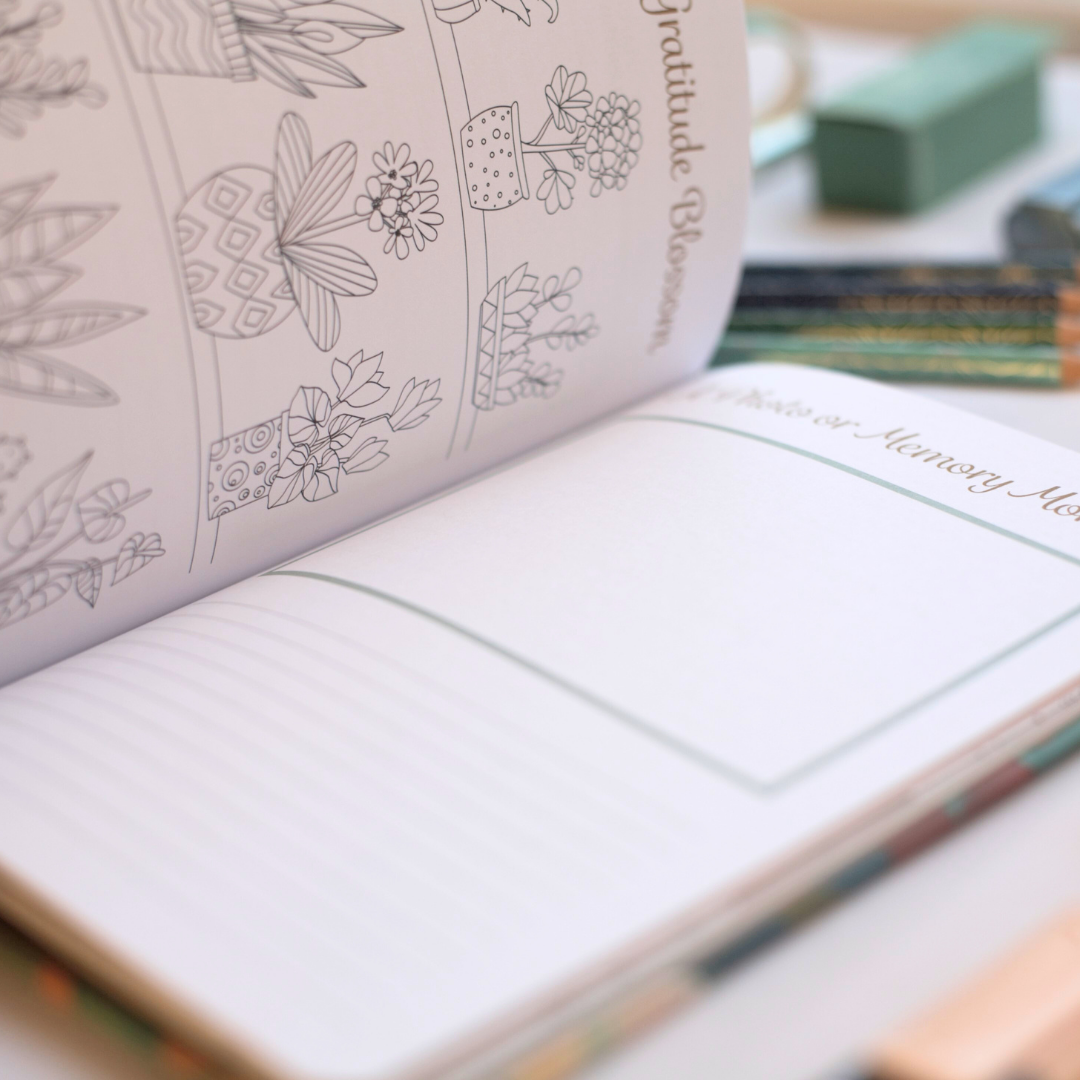 Open journal with floral illustrations and lined pages to capture memories on a blurred background