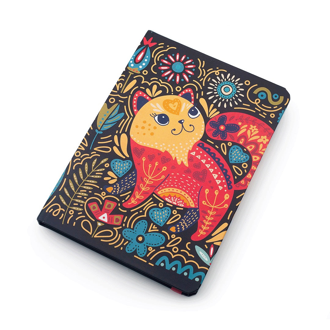 A hardcover notebook or journal featuring a colorful folk-art style illustration of a cat on a dark navy cover, photographed on a clean white background.