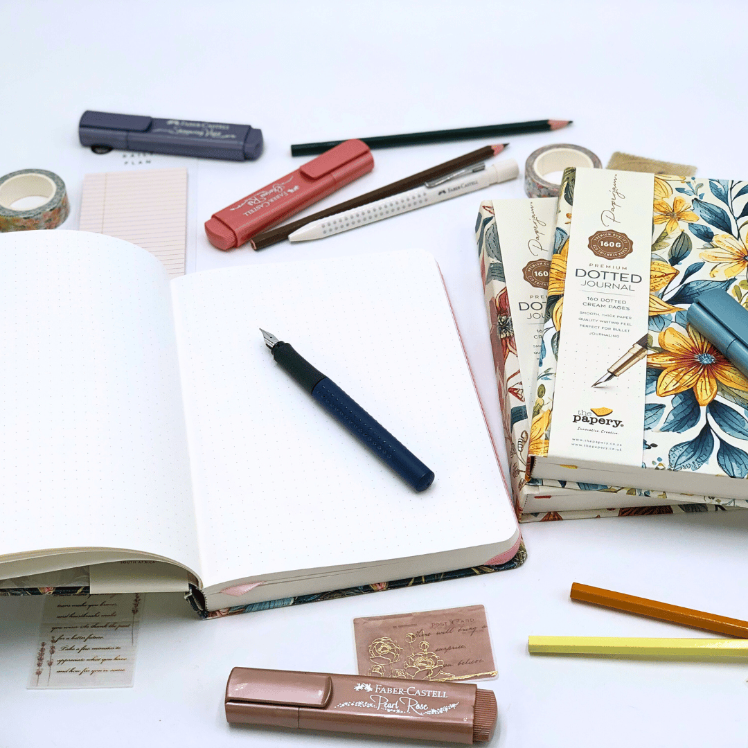 Stationery items including notebooks, pens, and a ruler on a white surface