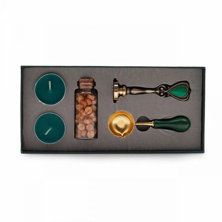 Sealing Wax Set of wax sealing tools including two teal candles, a jar of sealing wax, and two gold and green seals in a black box.