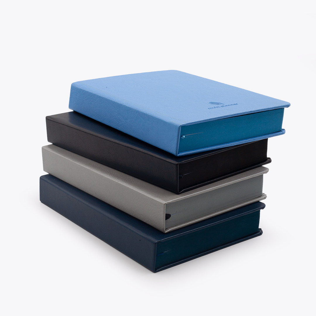 Stack of four classic multi planners in blue, black, gray, and navy on a white background