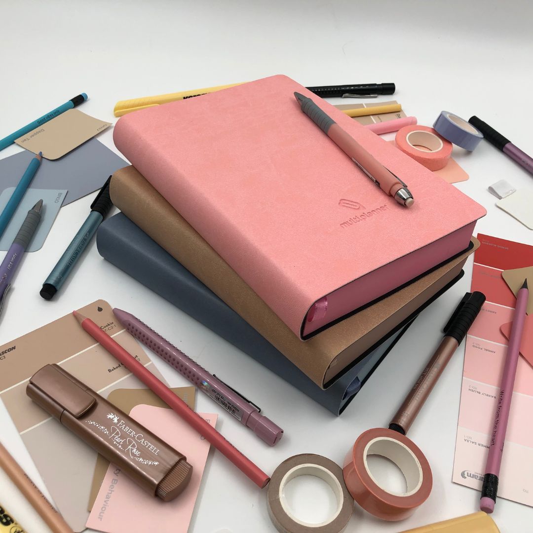 Collection of must have stationery items including multi planners, pens, and markers on a white background