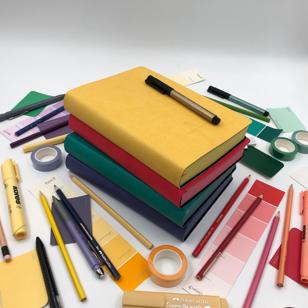 Colorful stationery items including multi planners, pens, and markers on a white background