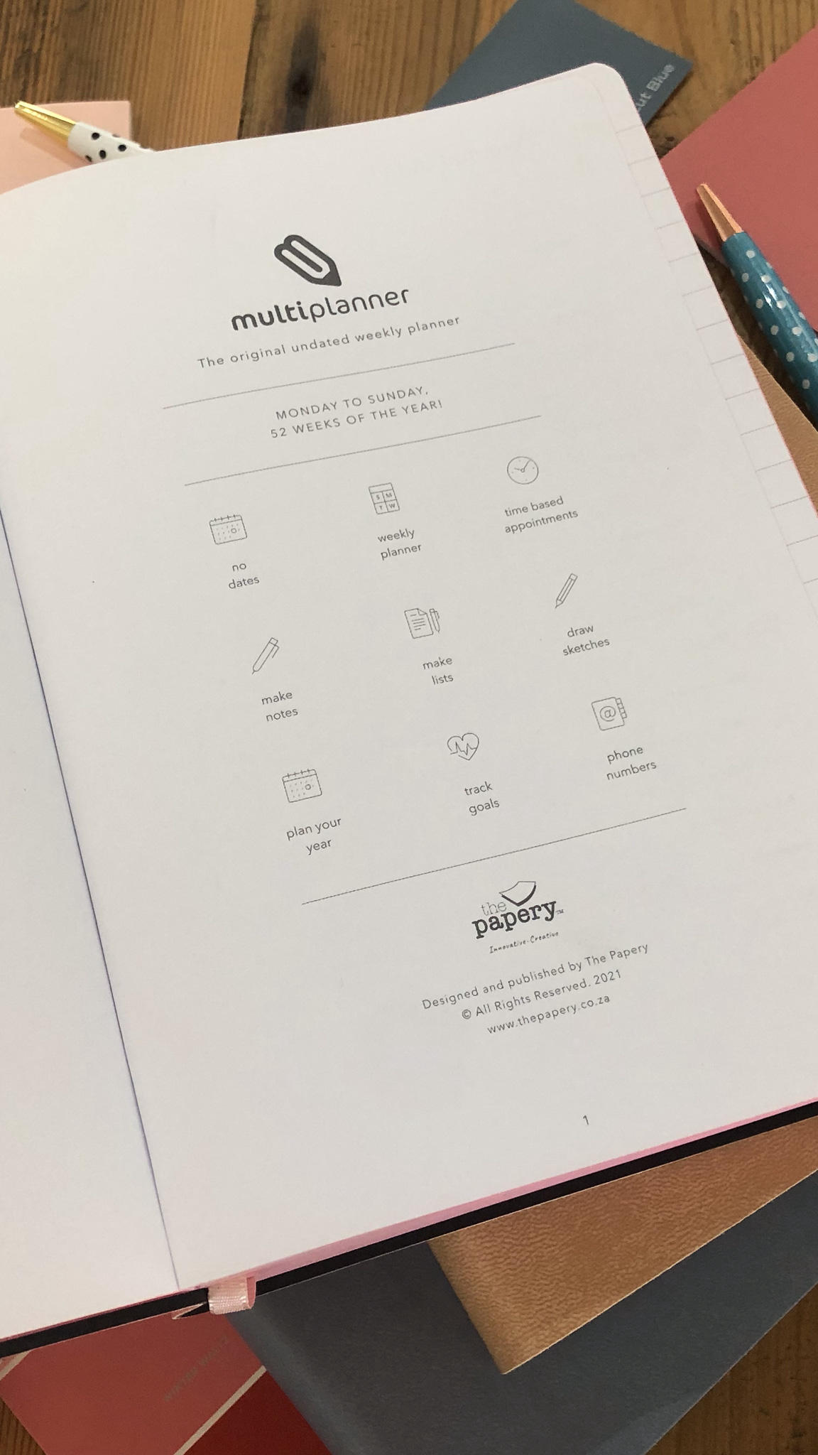 icons of the multi planner and branding on a wooden surface