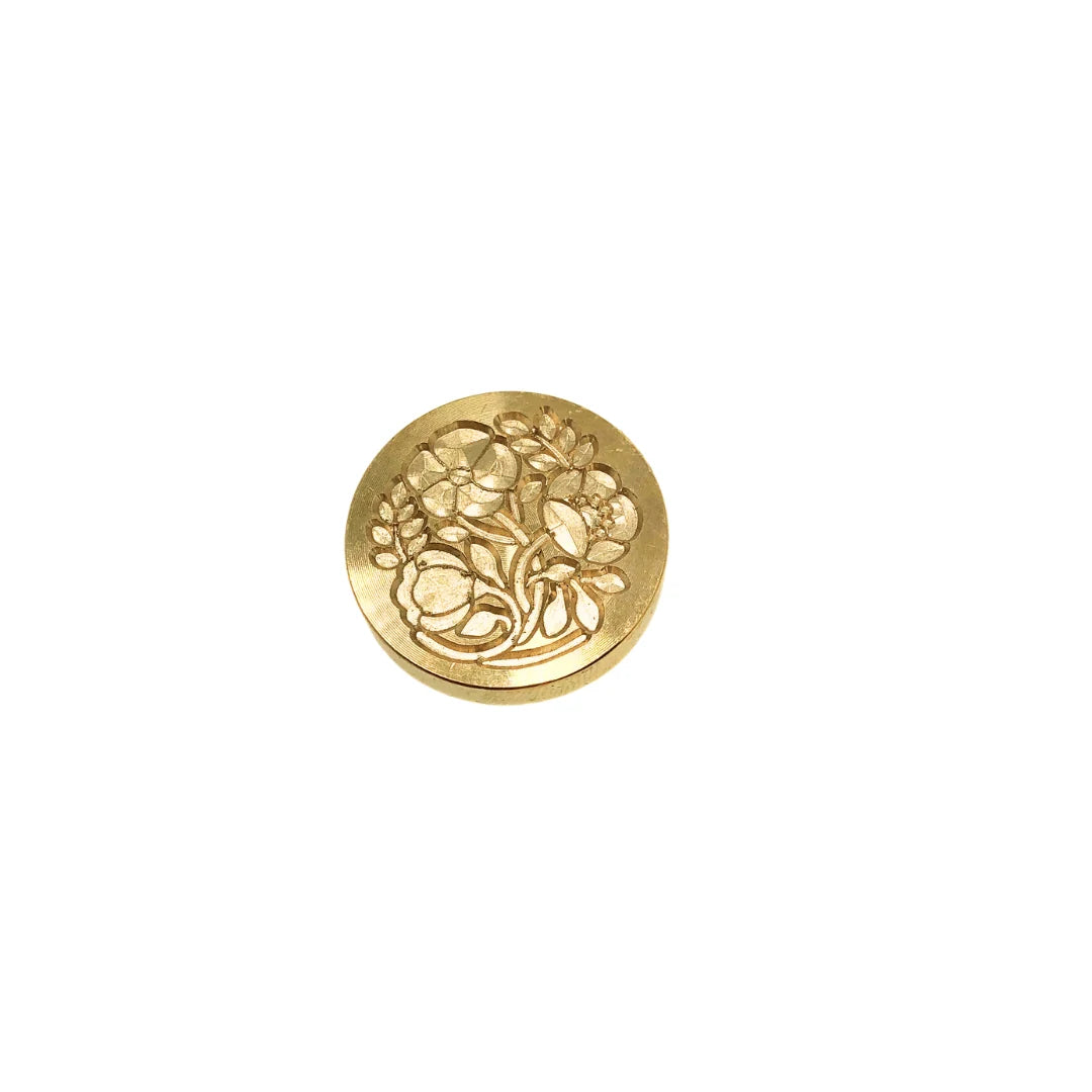 A single round gold-toned stamp-seal with an embossed floral pattern, centered on a plain white background.