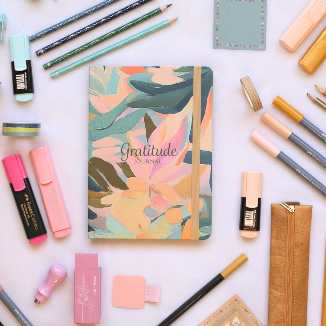 Floral Gratitude Journal with 'Gratitude' text surrounded by  Lifestyle stationery items on a white background