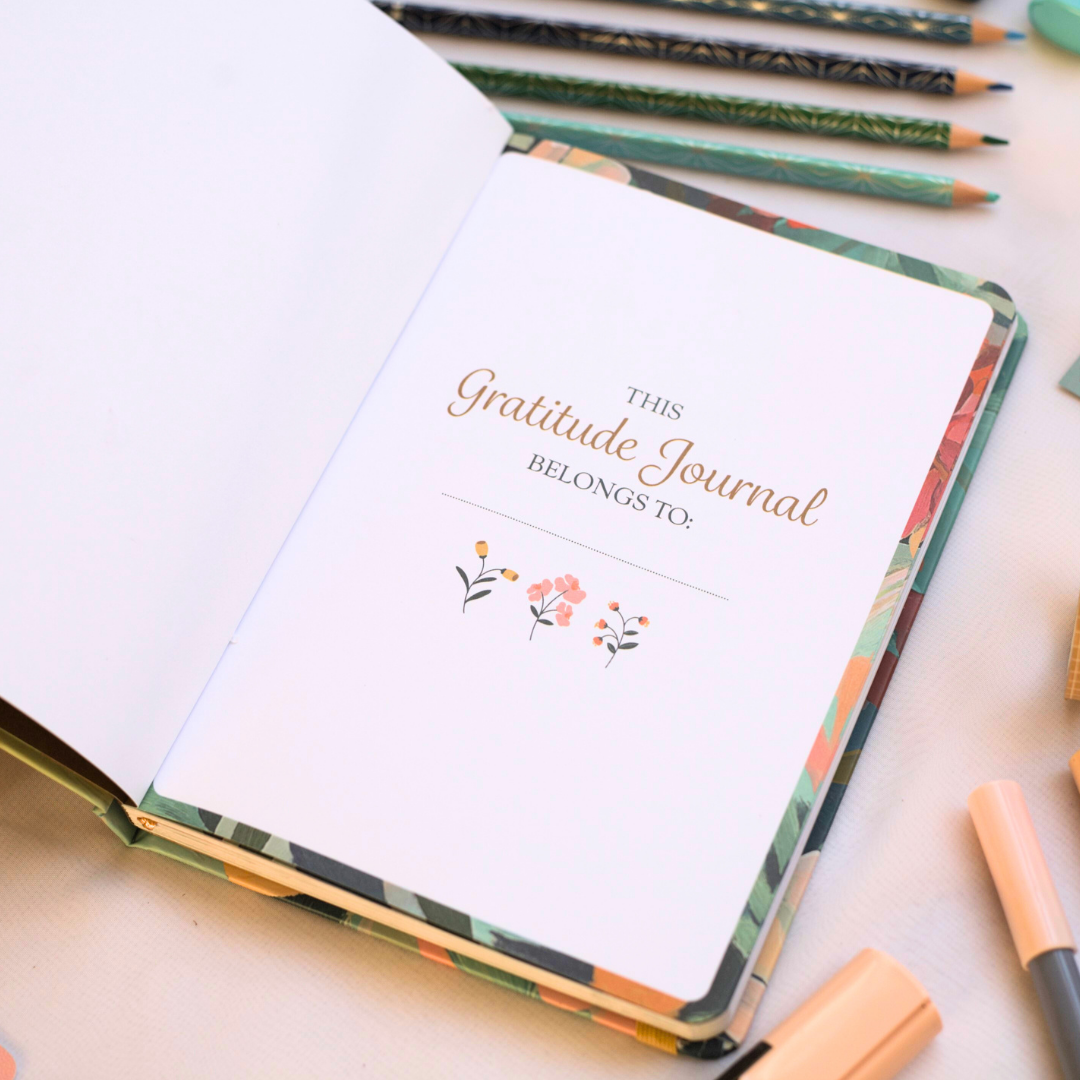 Gratitude journal with floral design so you can personalize and stationery items on a light surface