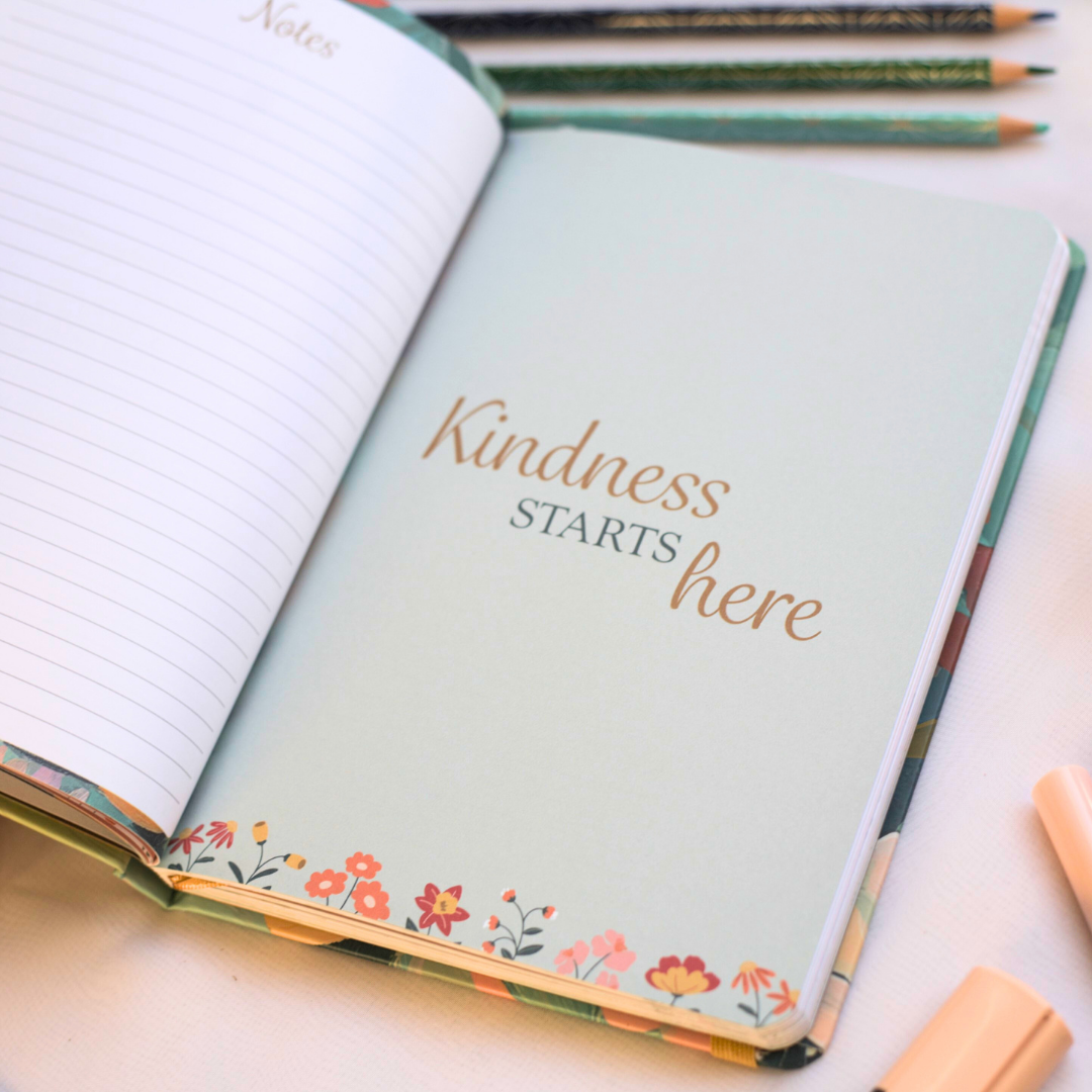 Journal with 'Kindness Starts Here' text on a light background