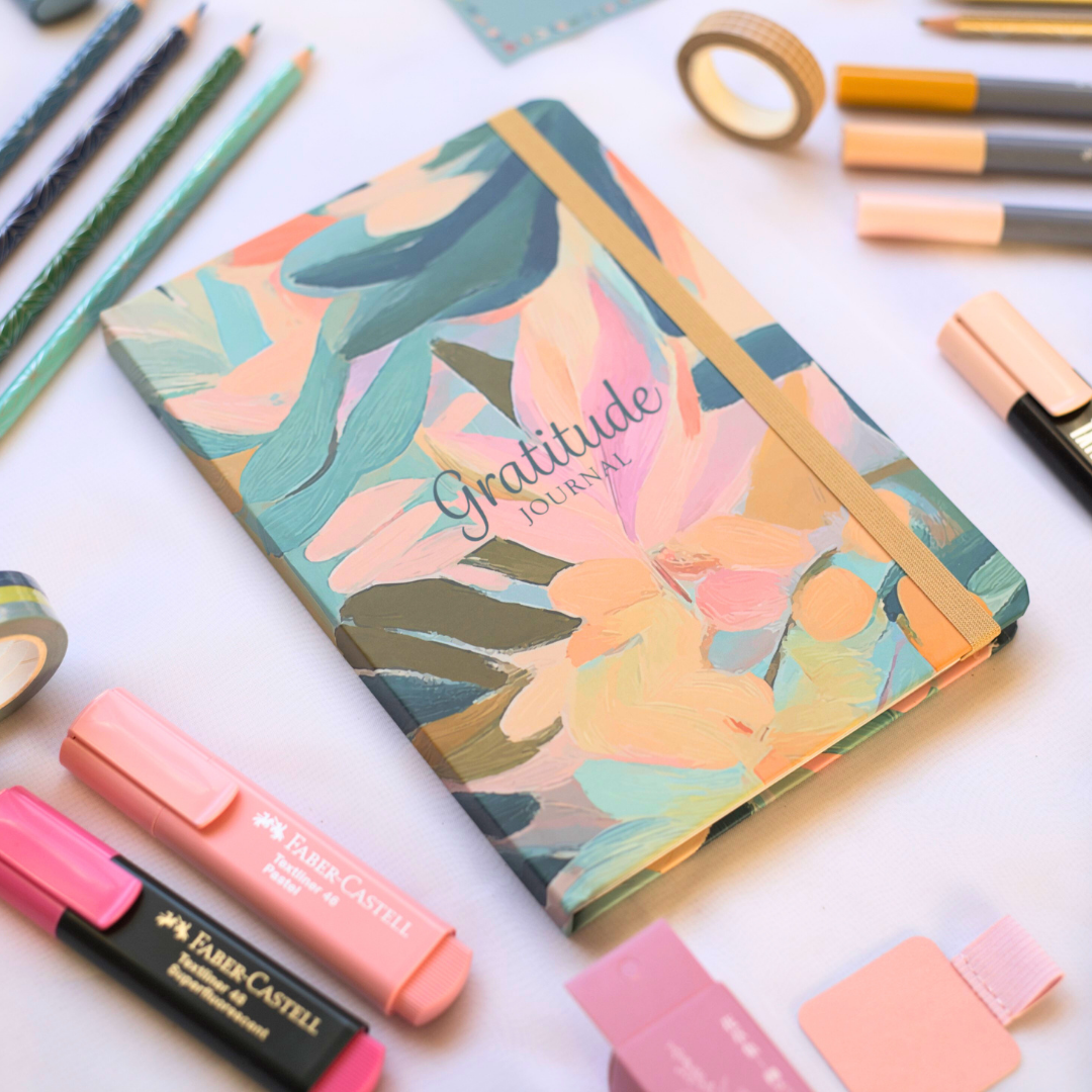 Floral Journal with 'Gratitude Journal' text surrounded by stationery items on a white background
