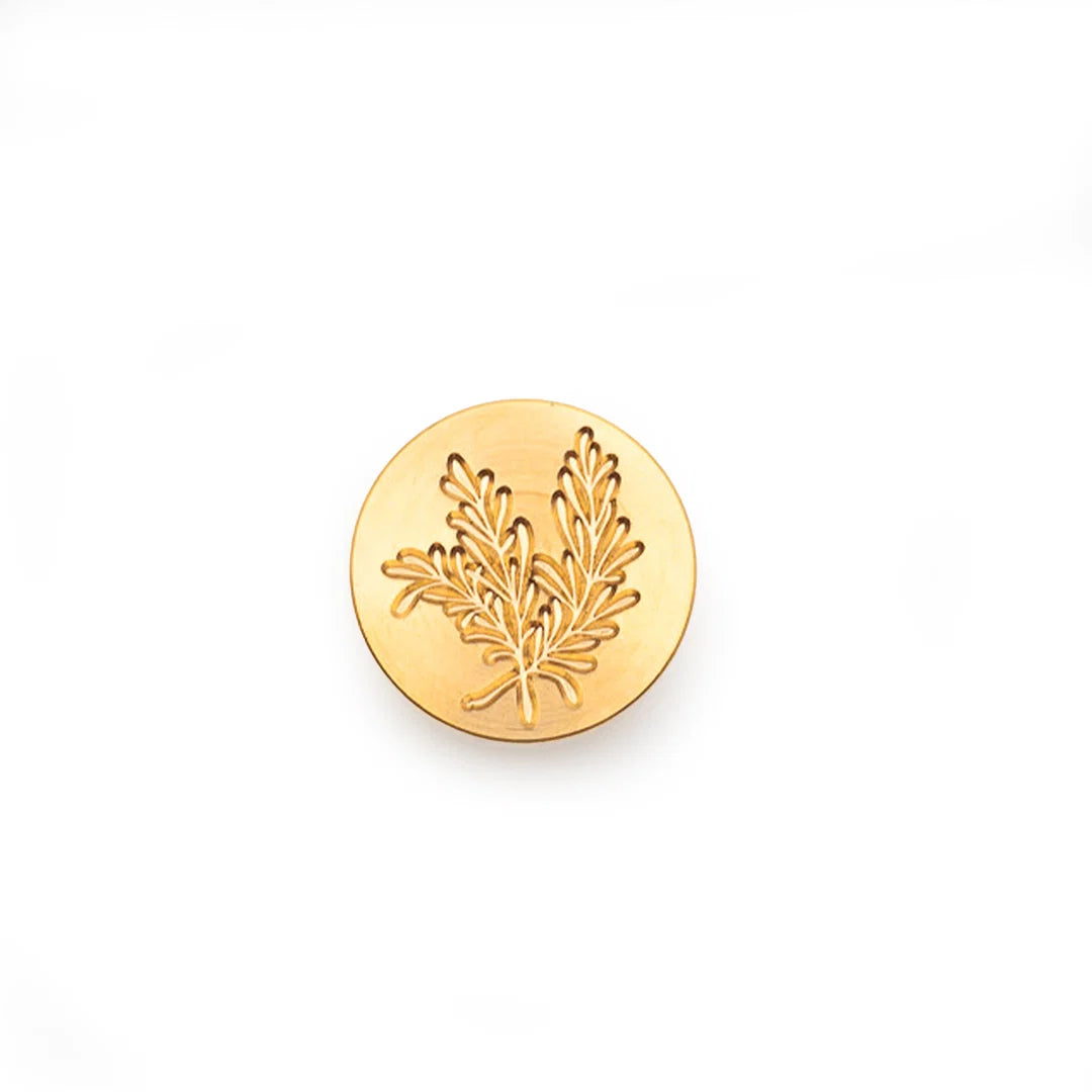 A round gold stamp-seal featuring an embossed leaf design, centered on a clean white background.