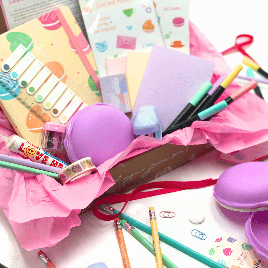 Love and Macaron Gift Box has assorted stationery items including notebooks, pens, and a pastel eraser on a white background.