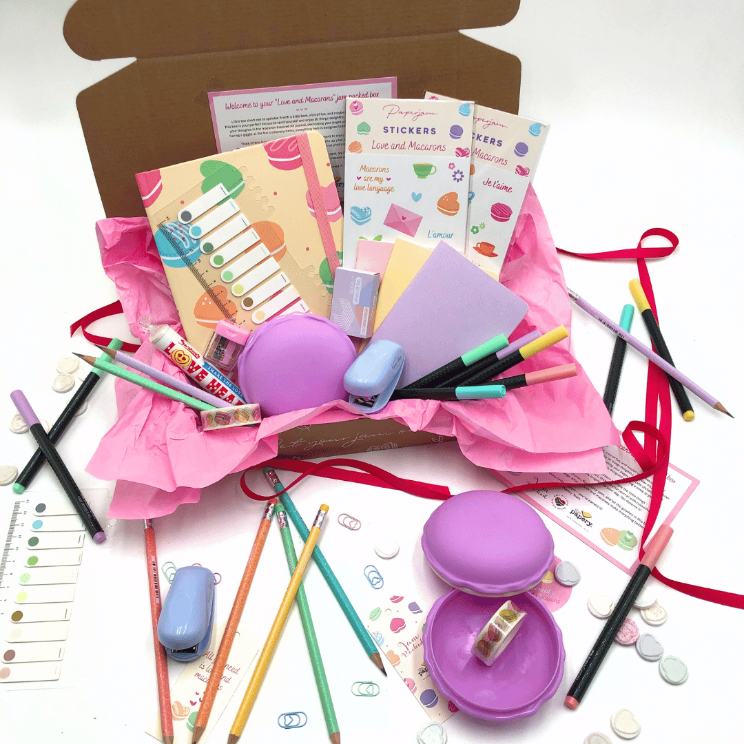 Love and Macaron Gift Box has plenty of stationery items including pencils, erasers, and stickers in a box on a white background