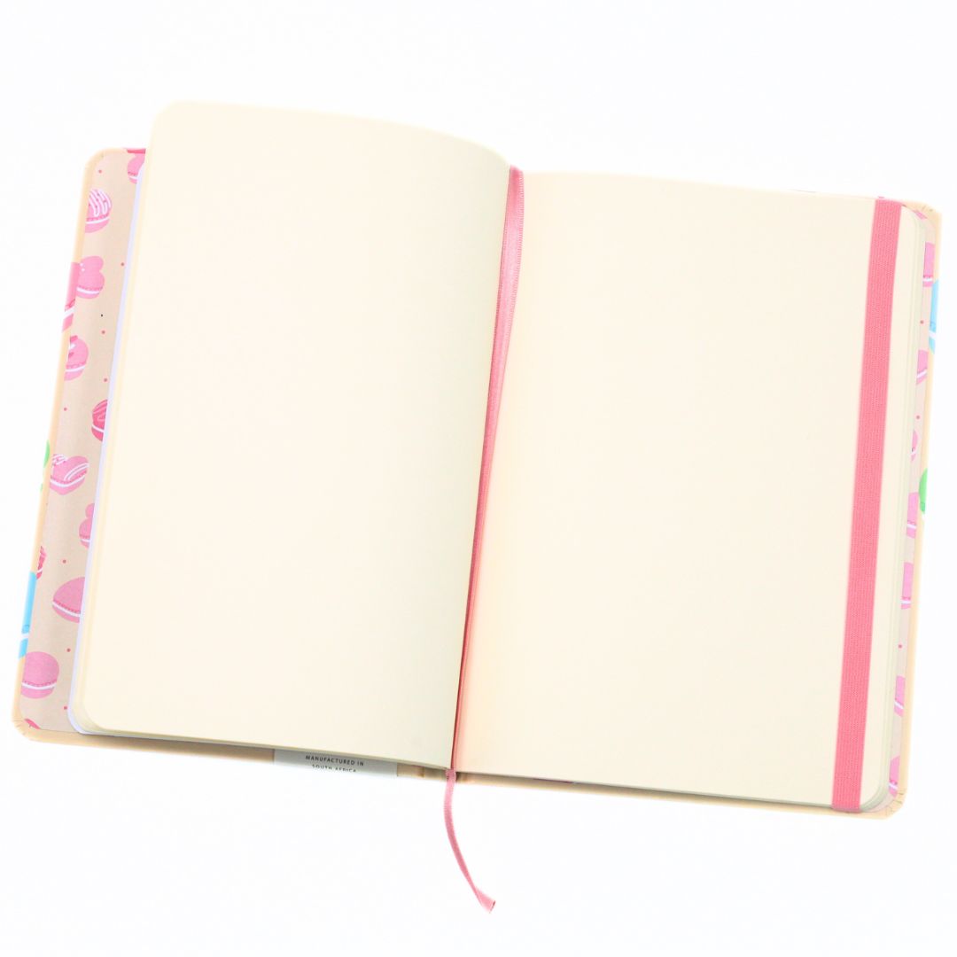 An open notebook with blank cream-colored pages, a pink elastic closure, and a pastel pink cover decorated with a cupcake pattern, shown on a solid white background.