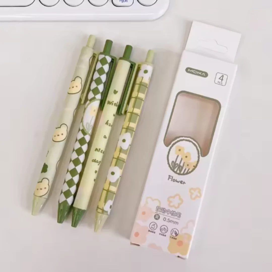 Matcha Green Pen Set of four ballpoint pens with unique matcha designs next to their packaging on a light gray background