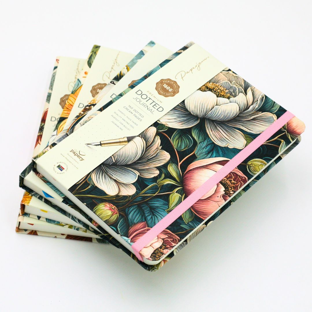 Stack of premium hardcover dotted journals on a white background