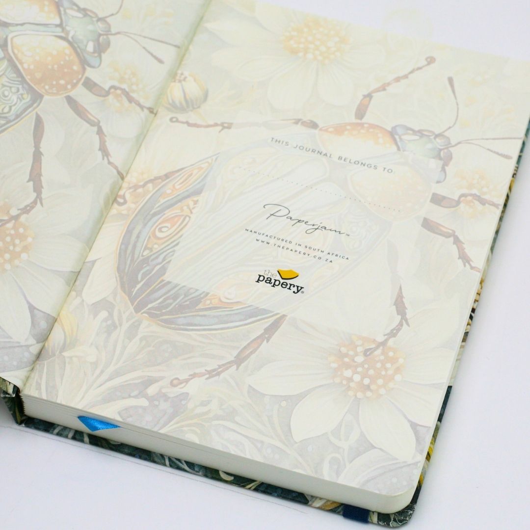 End papers of premium hardcover dotted journal with iridescent scarab design on a white background