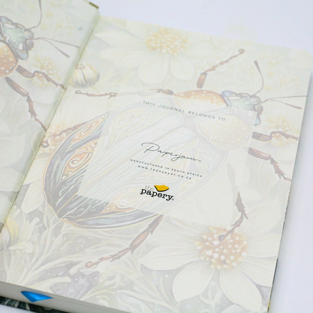 Personalization features of premium hardcover dotted journal with iridescent scarab design on a white background