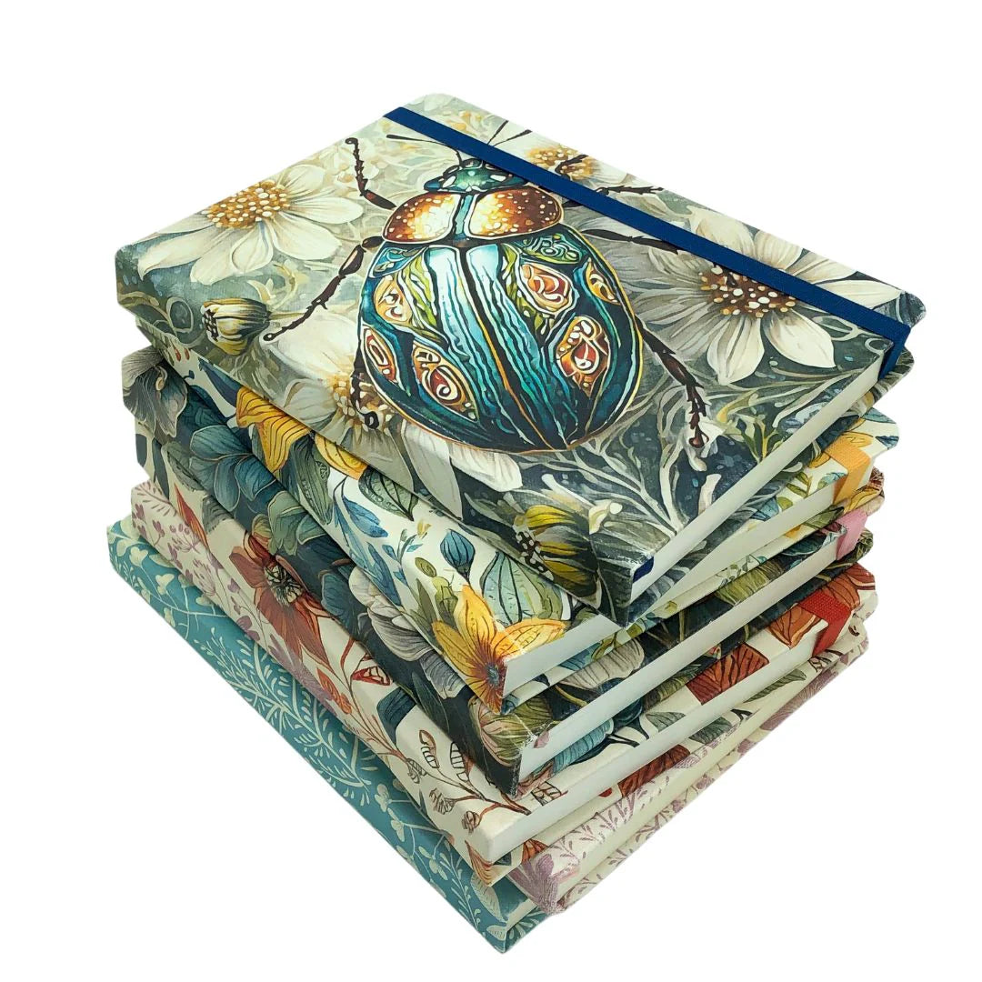 Stack of Premium Dotted Designer Journal A5 with designs and matching ribbons on a white background