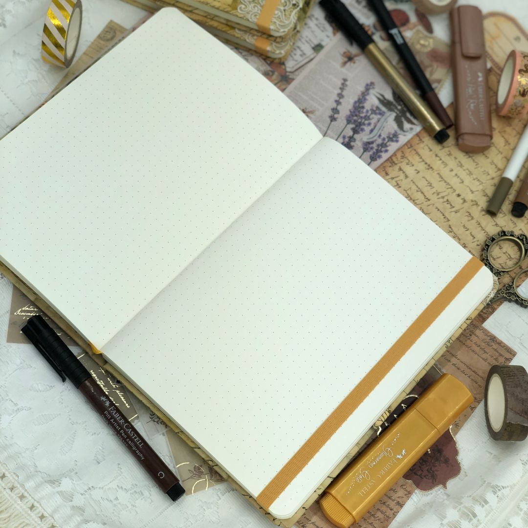 Open Junk Journal with stationery items on a textured surface