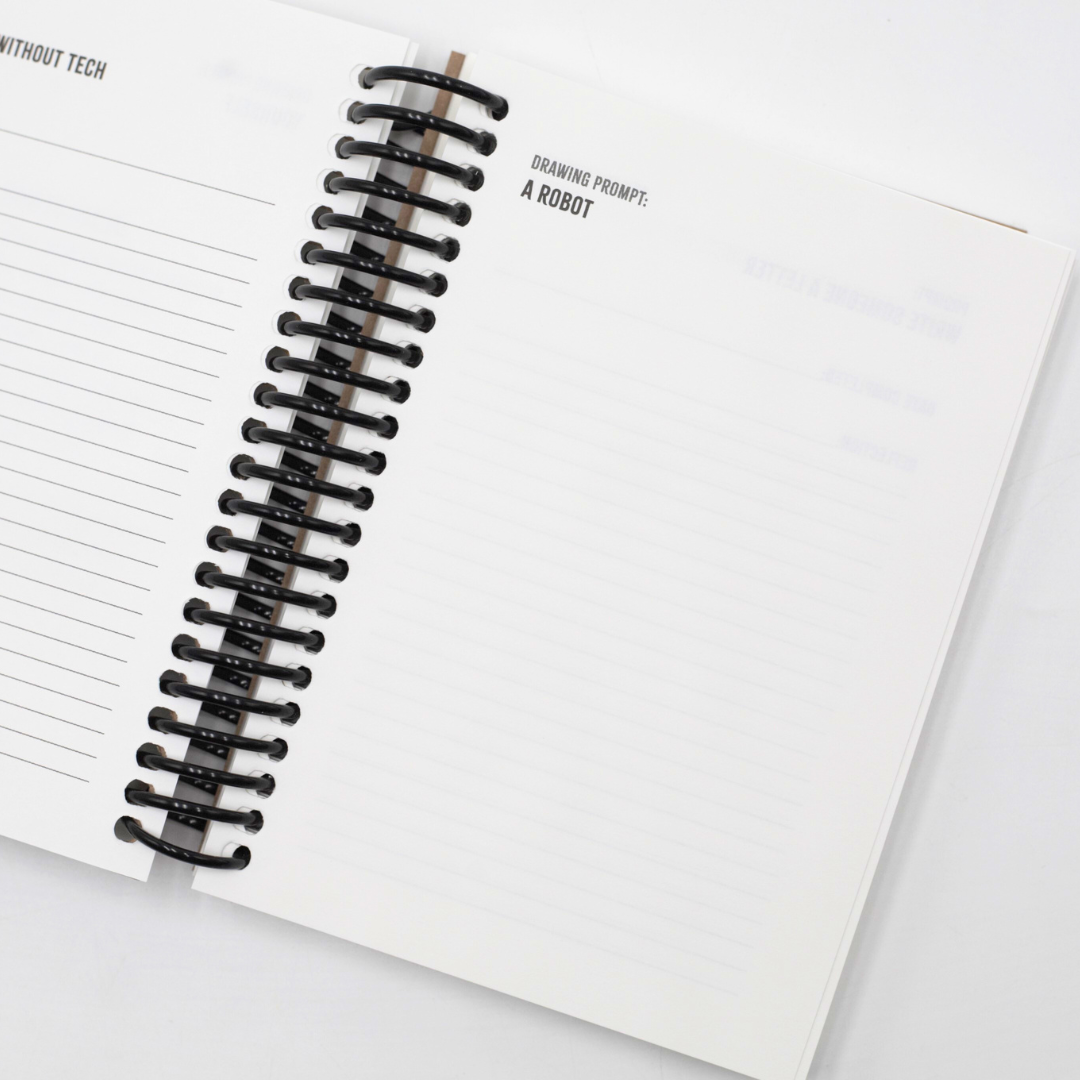 Open Digital Detox Reset Journal with a black spiral binding nd drawing prompts on a white background