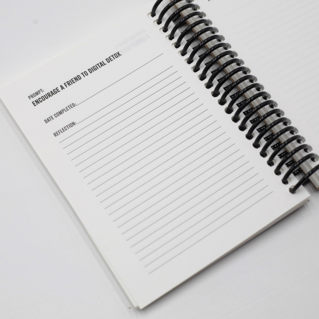 Spiral-bound Digital Detox Reset Journal with interactive prompts on lined pages on a white background