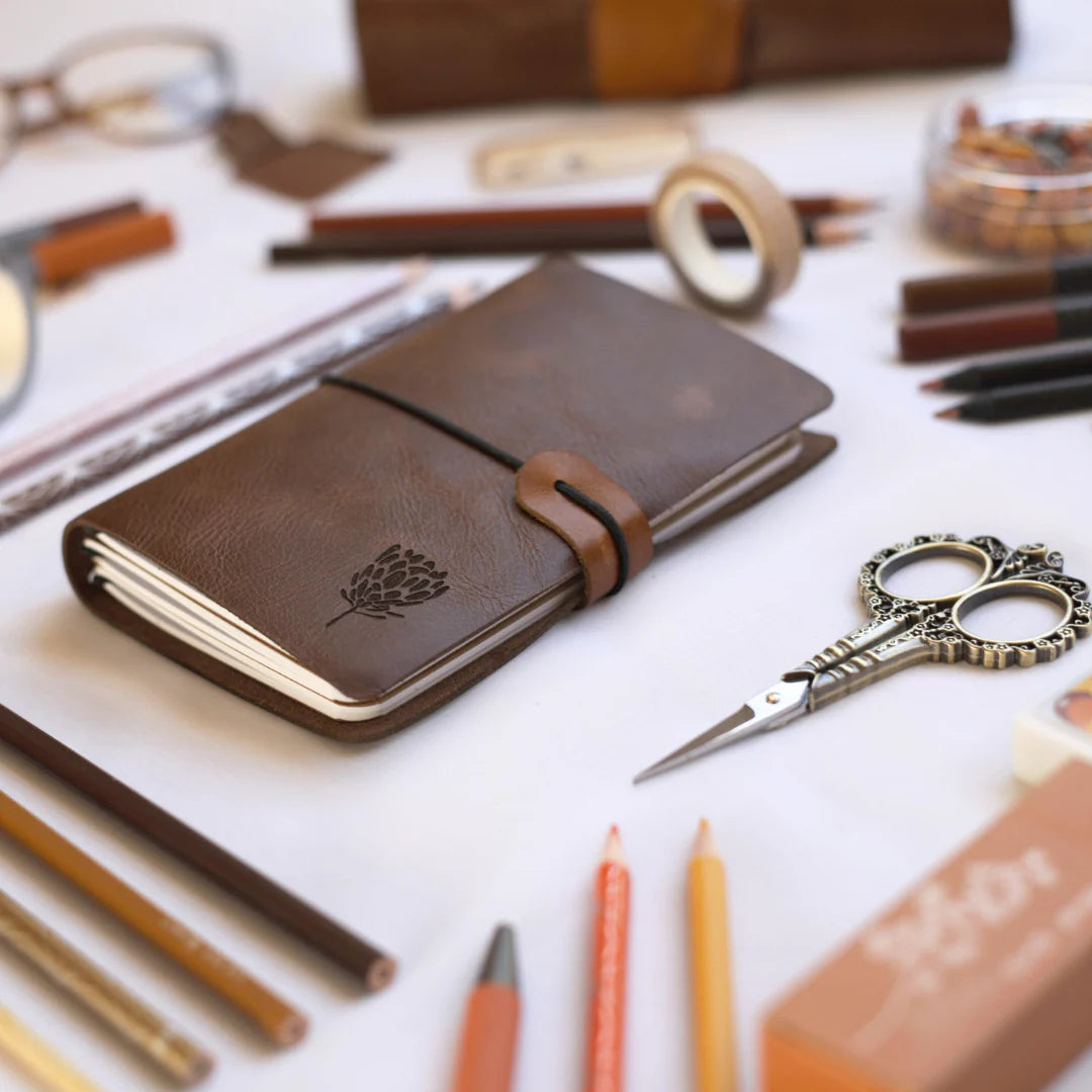 Rustik leather Notebook surrounded by stationary 