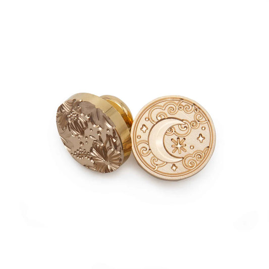 Two round gold-toned decorative plugs with engraved celestial and floral designs, displayed on a clean white background.
