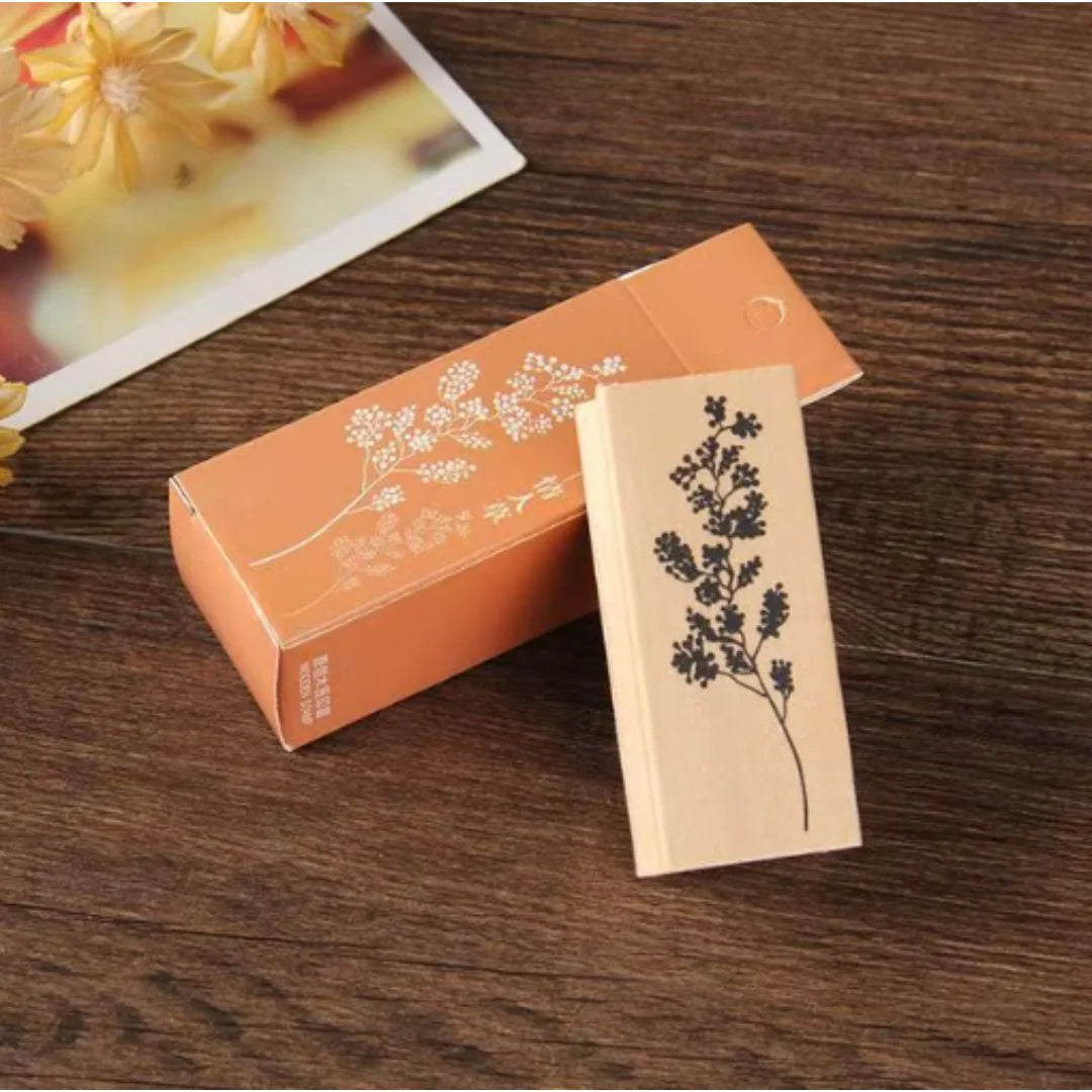 Wooden block Stamps with leaves design on a wooden surface next to an orange box.