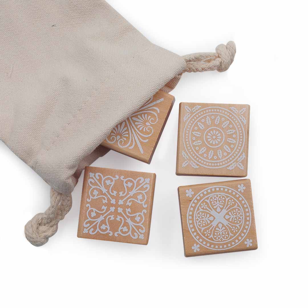 Four square tiles Wooden block Stamps with decorative patterns on a beige fabric pouch.